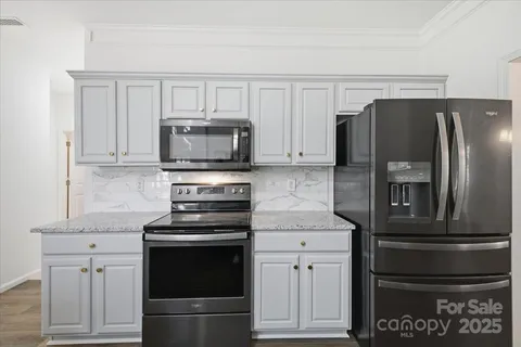 a kitchen with white cabinets and stainless steel appliances
