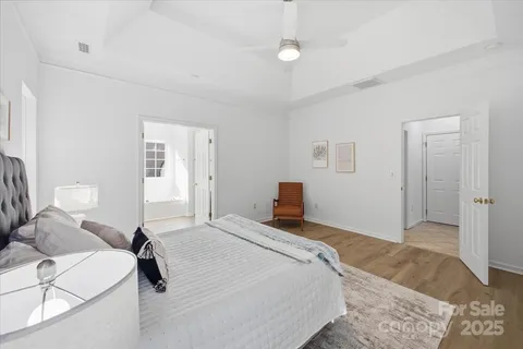 a bedroom with a bed and wooden floor