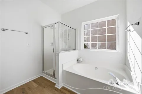 a bathroom with a tub shower and a window
