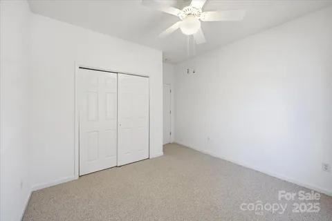 an empty room with a fan & a fan