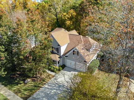 a view of a house with a yard and large trees