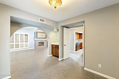 an empty room that has a window and kitchen view