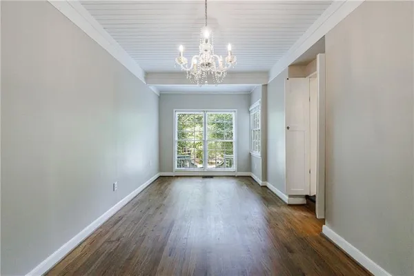 a view of an empty room with wooden floor and a fireplace