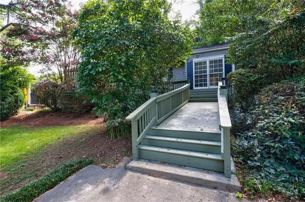a view of backyard with wooden fence and large trees