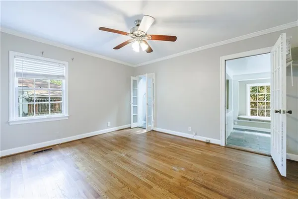 an empty room with wooden floor and windows