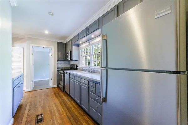 a kitchen with wooden cabinets sink and stainless steel appliances
