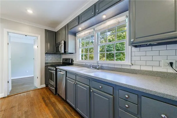 a kitchen with stainless steel appliances granite countertop a stove microwave and cabinets