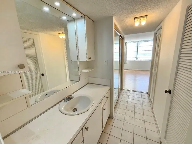 a bathroom with a sink a toilet a mirror and shower