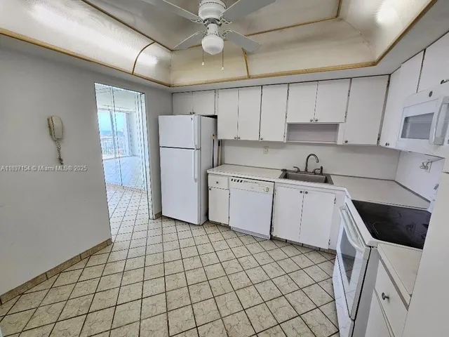 a kitchen with a sink a refrigerator and cabinets