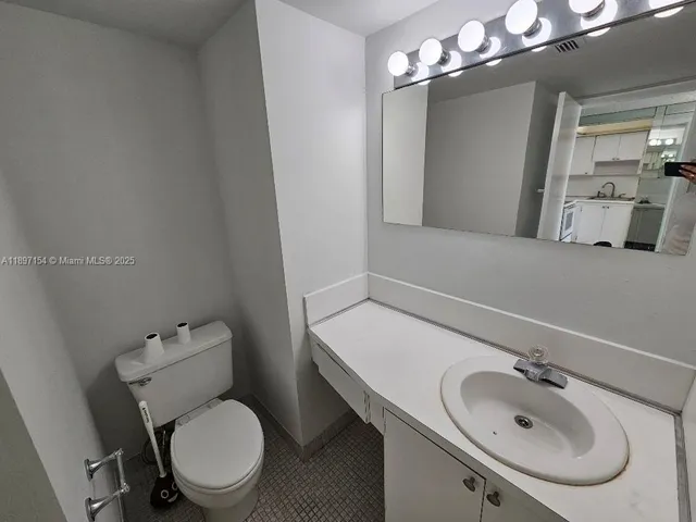 a bathroom with a sink and mirror with toilet