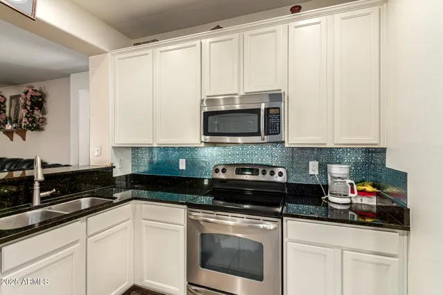 a kitchen with stainless steel appliances granite countertop white cabinets and a granite counter tops