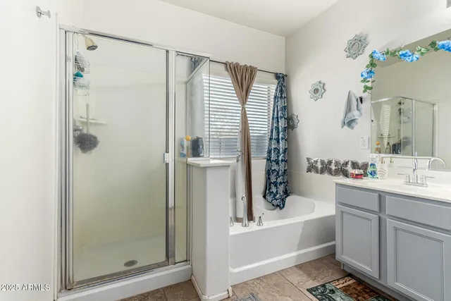 a bathroom with a tub shower sink and mirror