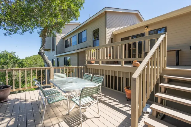 a view of a deck with two chairs and wooden floor