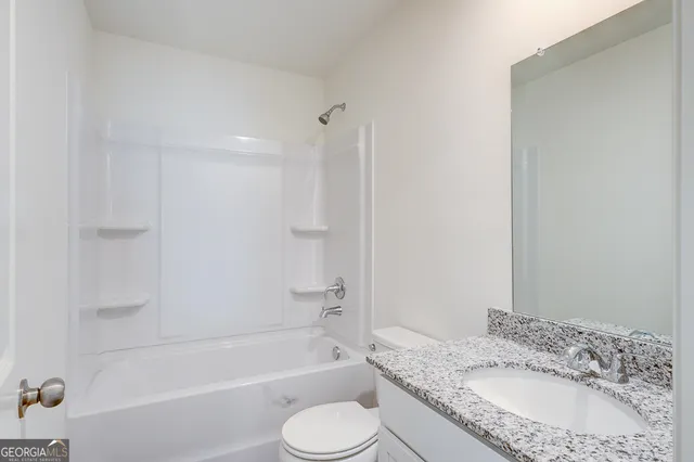 a bathroom with a granite countertop sink toilet bathtub and shower