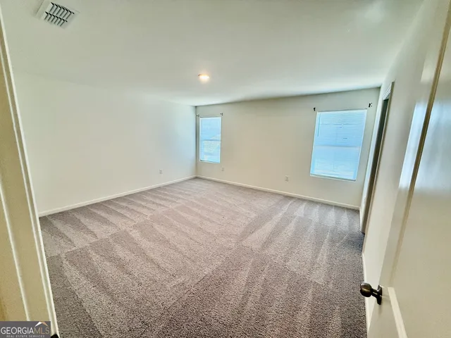 a bathroom with a granite countertop sink a toilet and a large mirror