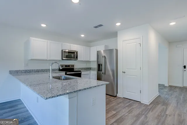 a kitchen with granite countertop a refrigerator and a sink