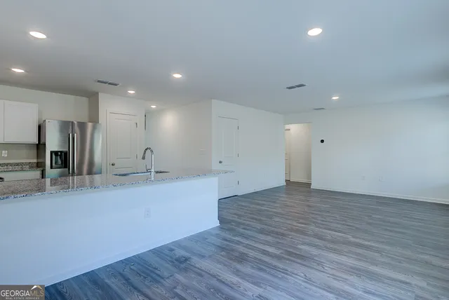 an empty room with wooden floor and a large window