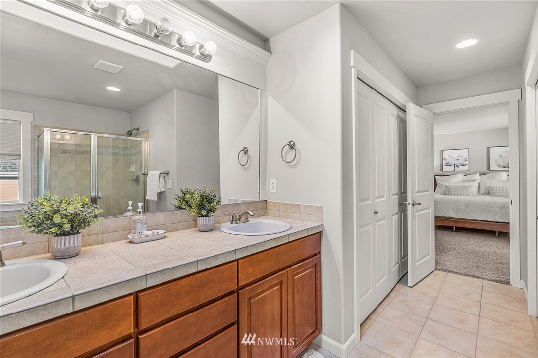 22424 6th Place West Bothell, WA 98021 - Photo 23 of 31 a bathroom with a granite countertop sink a large mirror and shower