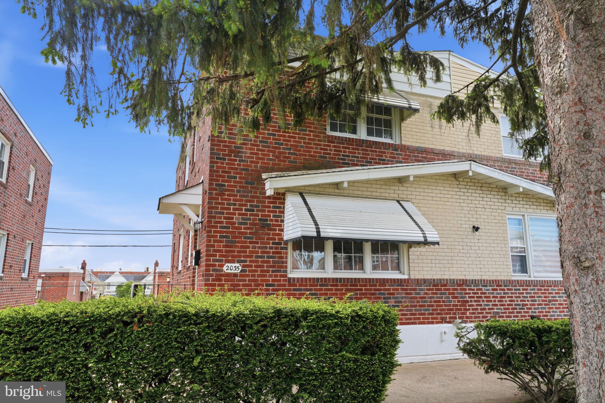 Charming brick duplex with greenery.