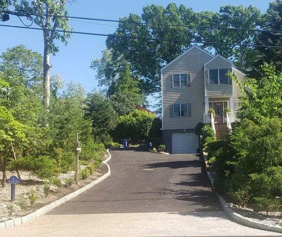 a front view of a house with a yard and trees