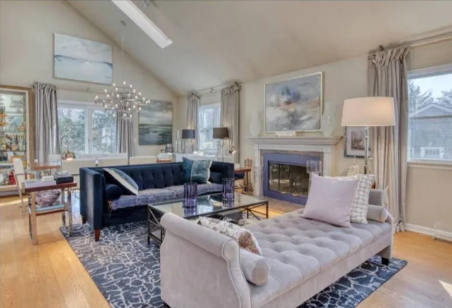 a living room with furniture a large window and a fireplace