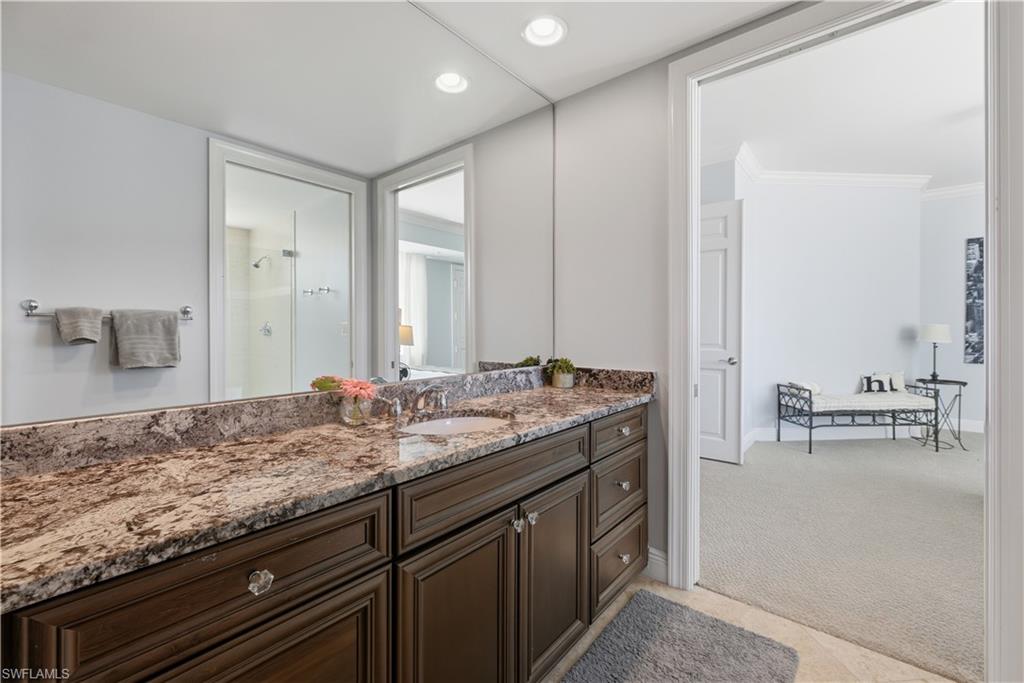 275 Indies Way, Unit 403 Naples, FL 34110 - Photo 11 of 50 a bathroom with a granite countertop sink and a mirror