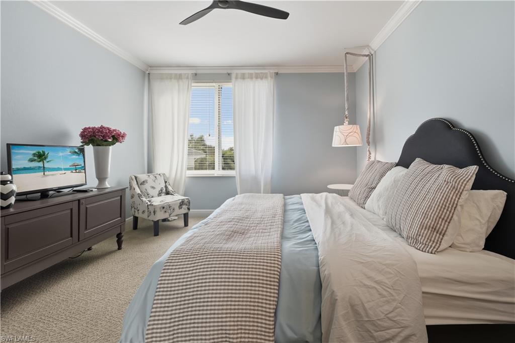 275 Indies Way, Unit 403 Naples, FL 34110 - Photo 13 of 50 a bedroom with a bed and wooden floor