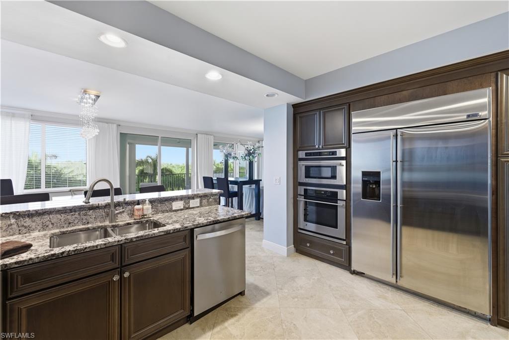 275 Indies Way, Unit 403 Naples, FL 34110 - Photo 21 of 50 a kitchen with a sink and stainless steel appliances