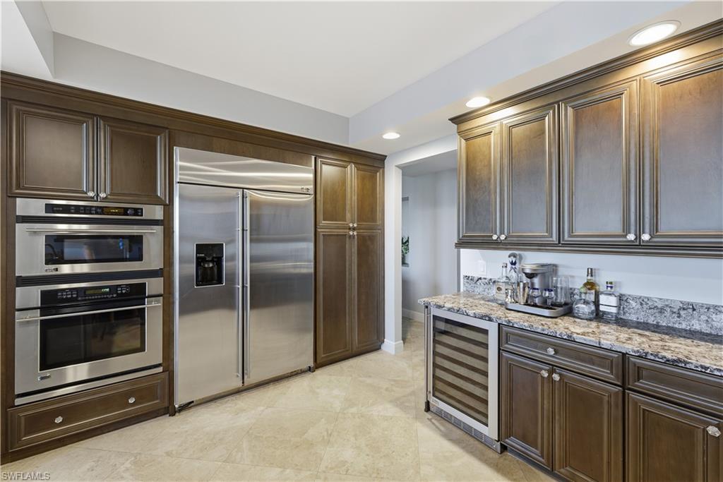 275 Indies Way, Unit 403 Naples, FL 34110 - Photo 22 of 50 a kitchen with stainless steel appliances a stove and a refrigerator