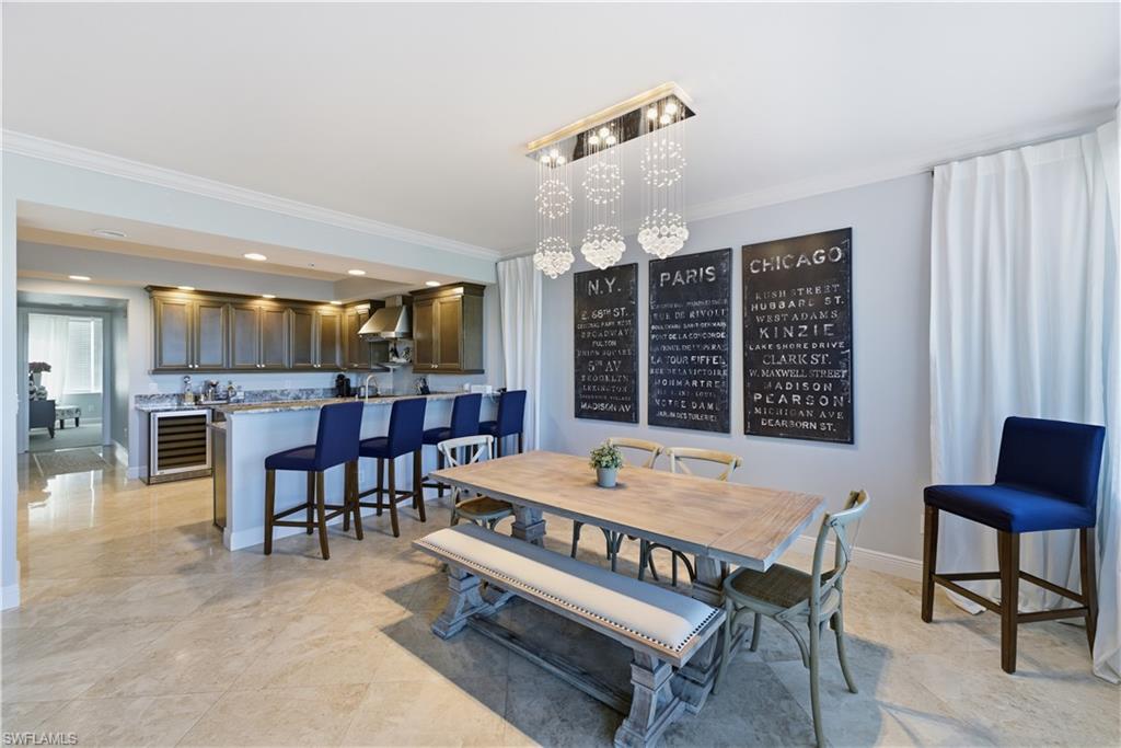 275 Indies Way, Unit 403 Naples, FL 34110 - Photo 23 of 50 a dining room with a wooden table and chairs