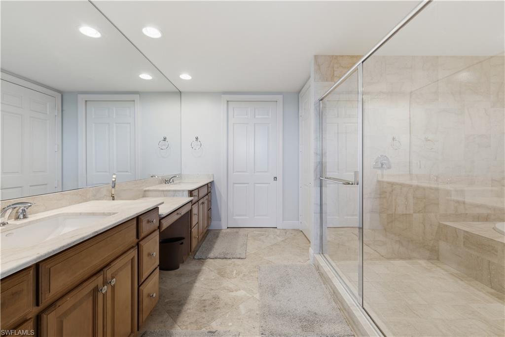 275 Indies Way, Unit 403 Naples, FL 34110 - Photo 31 of 50 a spacious bathroom with a shower sink and mirror
