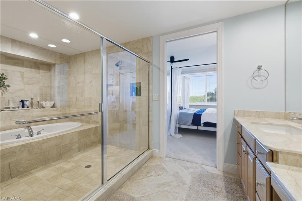 275 Indies Way, Unit 403 Naples, FL 34110 - Photo 33 of 50 a en suite bathroom with a granite countertop sink a toilet and a shower