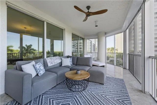 a living room with furniture and a floor to ceiling window