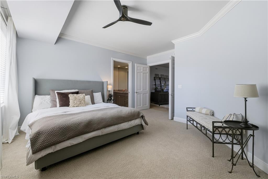 275 Indies Way, Unit 403 Naples, FL 34110 - Photo 8 of 50 a bedroom with a bed and a lamp