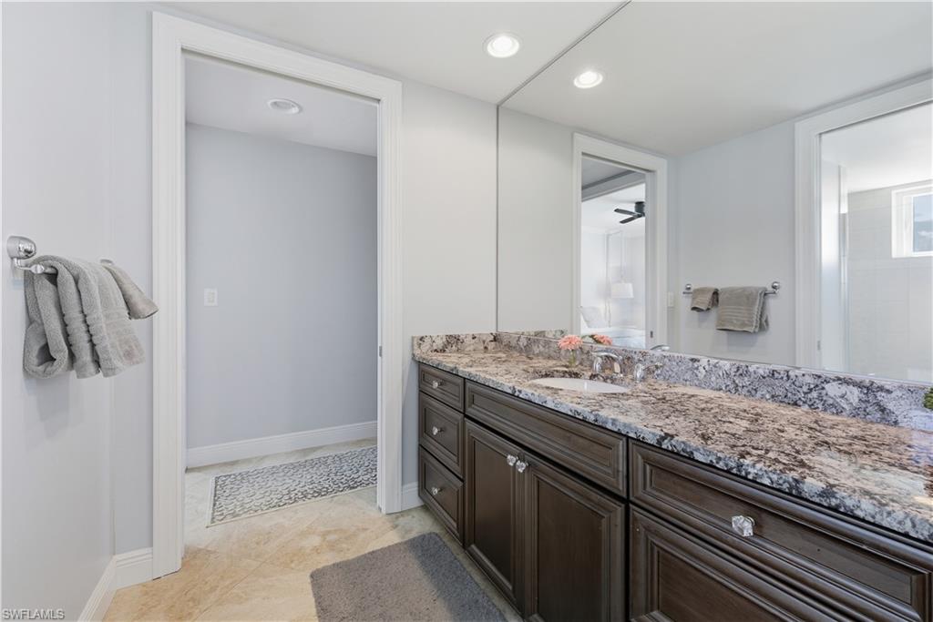 275 Indies Way, Unit 403 Naples, FL 34110 - Photo 9 of 50 a bathroom with a granite countertop sink and a mirror