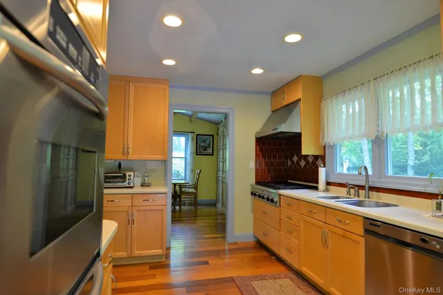 a large kitchen with a large counter top stainless steel appliances and cabinets