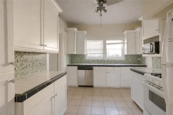 a kitchen with granite countertop a sink stainless steel appliances and cabinets