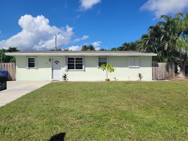a front view of house with yard and trees