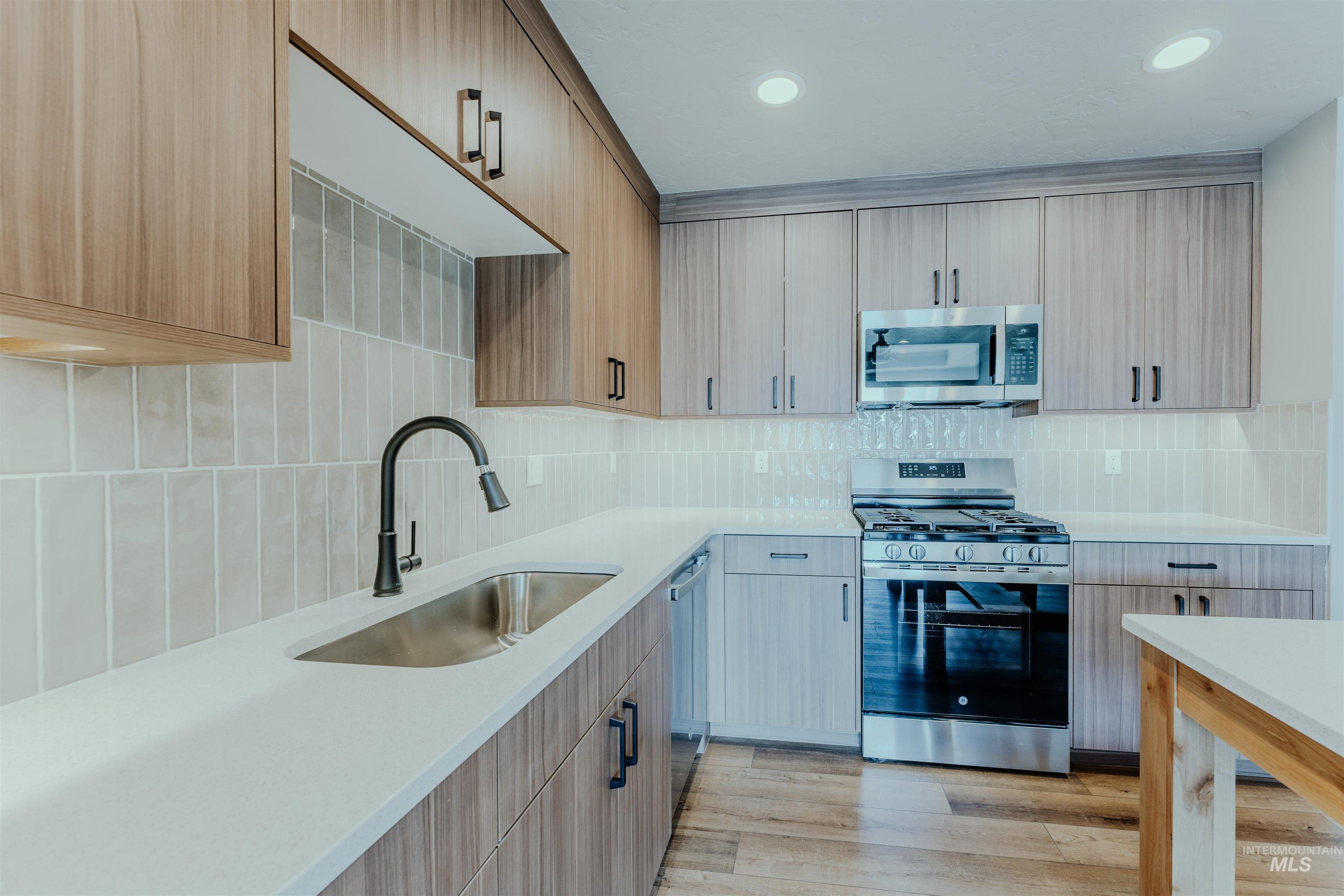 1233 Phillips Circle Ontario, OR 97914 - Photo 5 of 22 Kitchen with appliances with stainless steel finishes, light wood finished floors, tasteful backsplash, light stone countertops, and recessed lighting