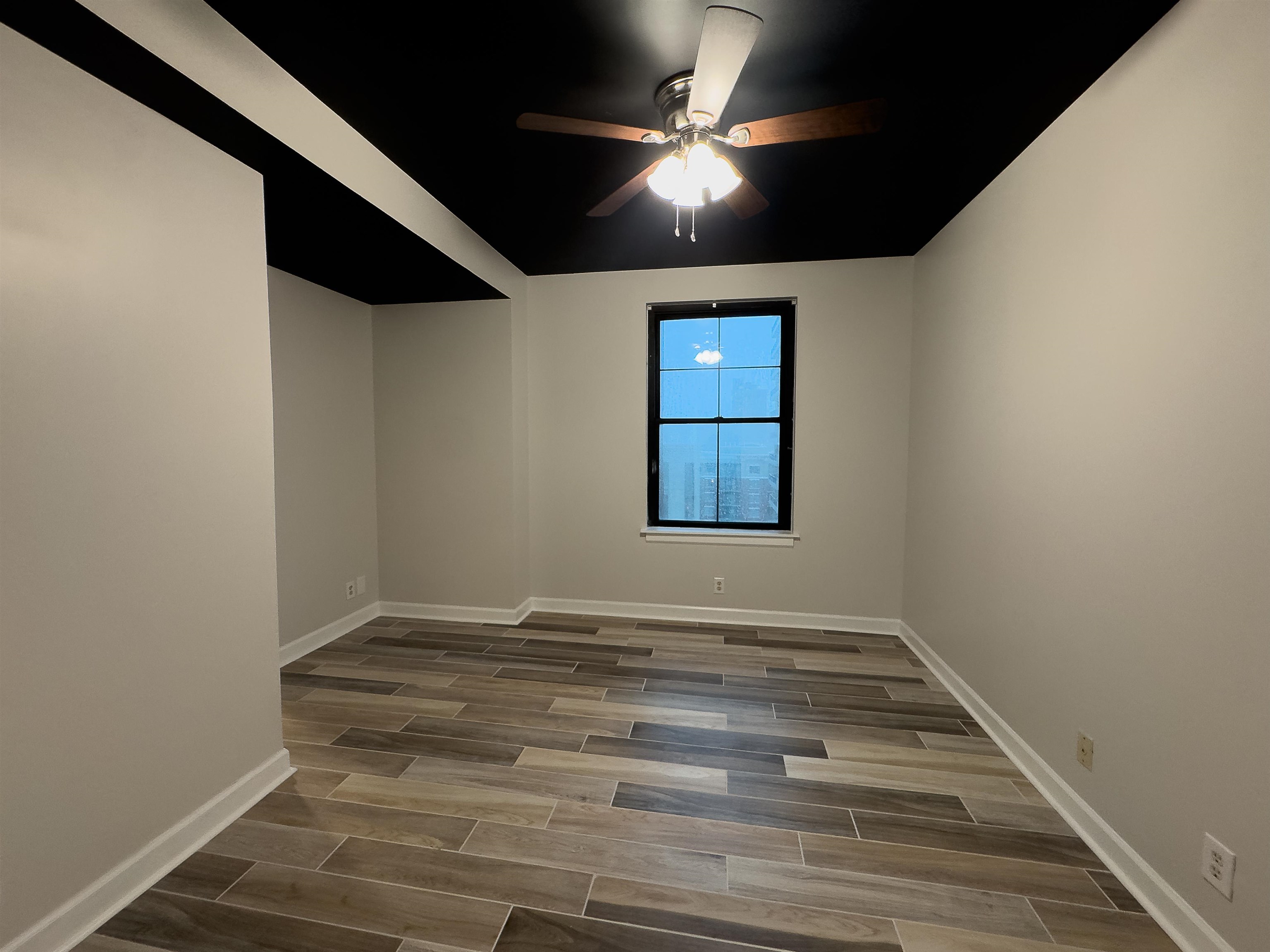 109 North Main Street, Unit 907 Memphis, TN 38103 - Photo 16 of 29 Room featuring wood-finish tile flooring, a black ceiling, and light gray painted walls