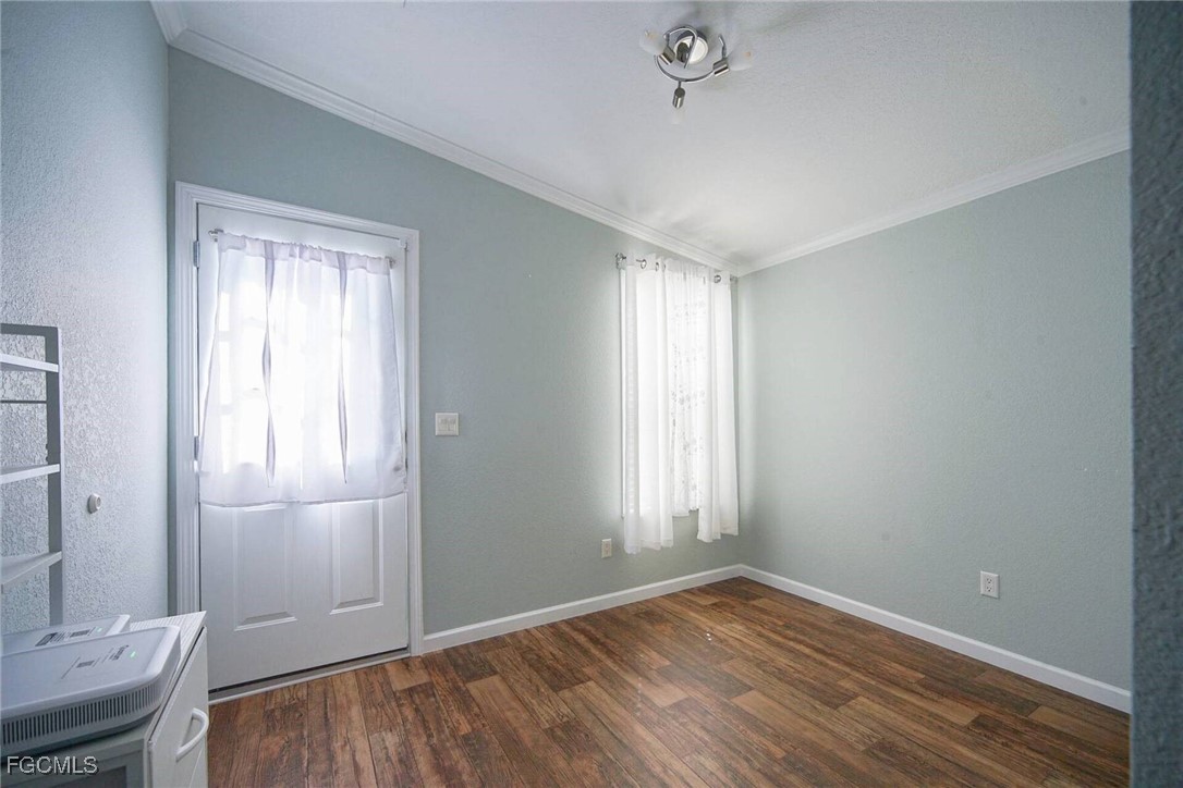 2831 York Road St. James City, FL 33956 - Photo 28 of 29 an empty room with wooden floor and windows