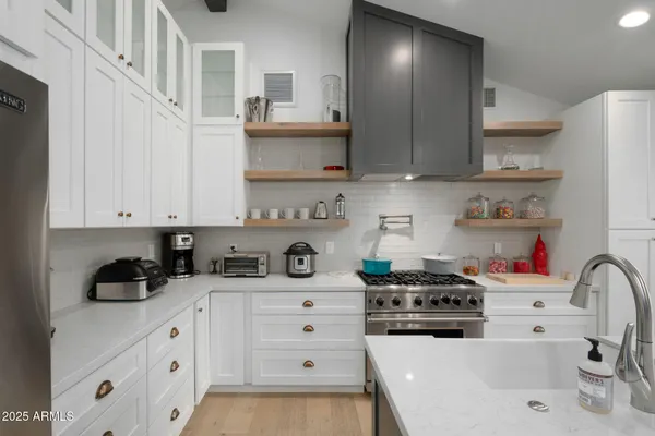 a kitchen with stainless steel appliances a sink a stove and cabinets