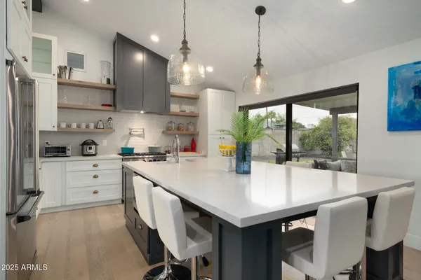 a large kitchen with kitchen island a table and chairs