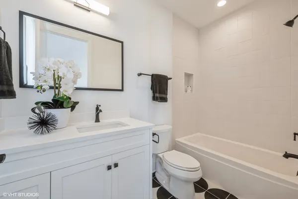 a bathroom with a sink toilet mirror and shower