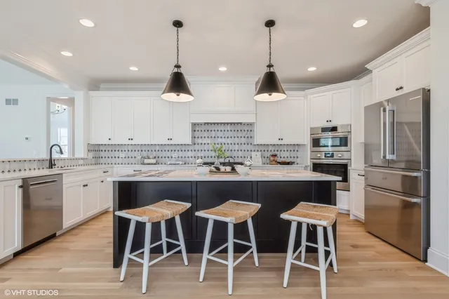 a kitchen with a dining table chairs sink and wooden floor