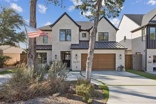a front view of a house with a yard garage and outdoor seating