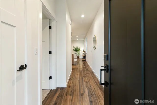 a view of a hallway with wooden floor and staircase