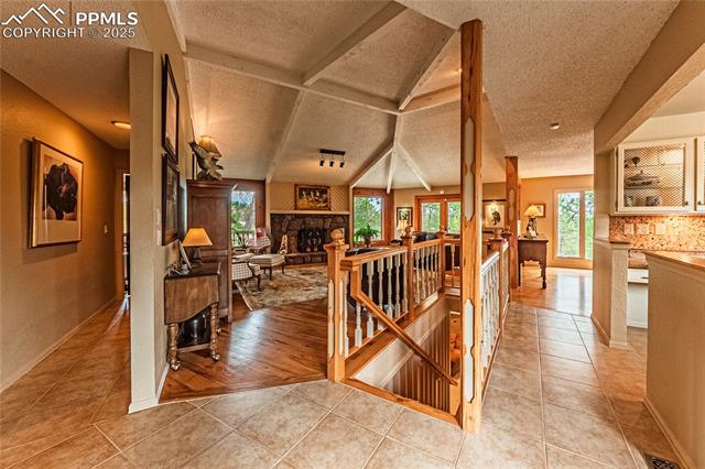 7175 Higher Ridges Court Colorado Springs, CO 80919 - Photo 8 of 50 Stairs featuring a fireplace, tile patterned flooring, and a textured ceiling