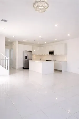 a view of a kitchen with a sink and a refrigerator
