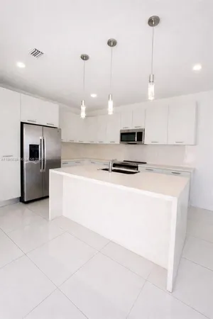 a kitchen with stainless steel appliances a refrigerator sink and microwave